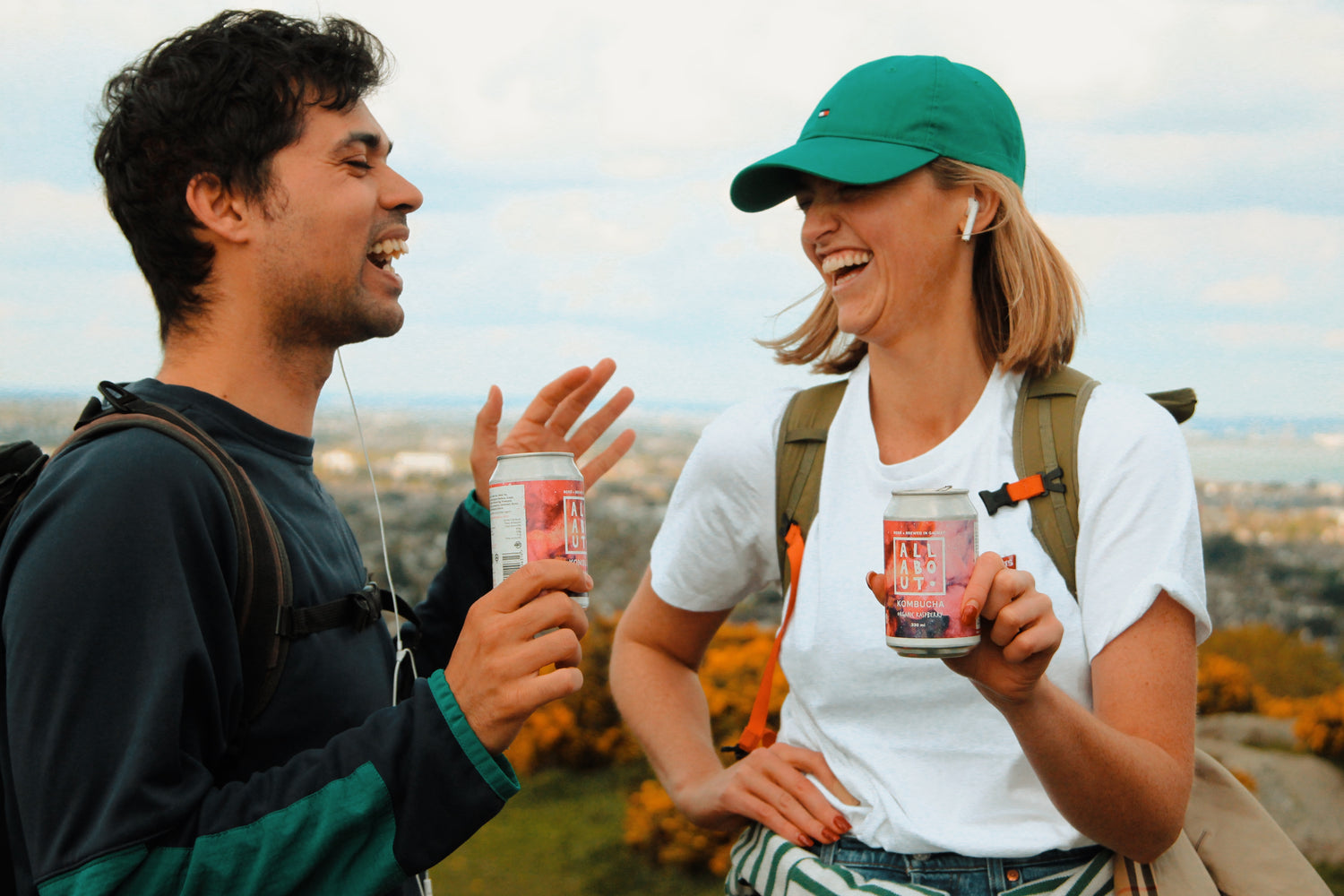 Two people enjoying kombucha cans