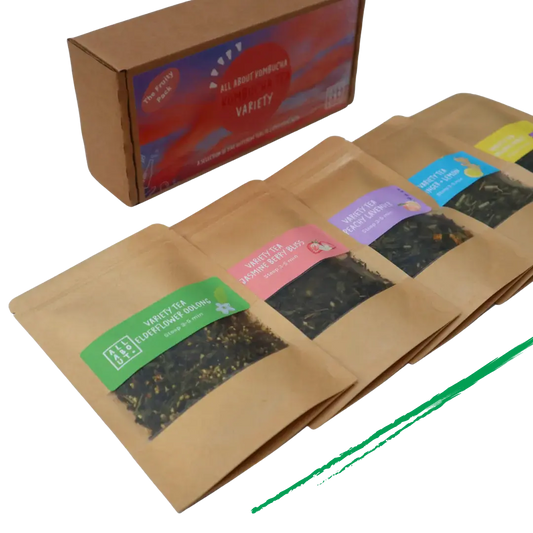 All About Kombucha tea variety pack featuring five kraft paper pouches of loose leaf tea blends, including elderflower oolong, berry bliss, and peach blossom, alongside branded packaging box